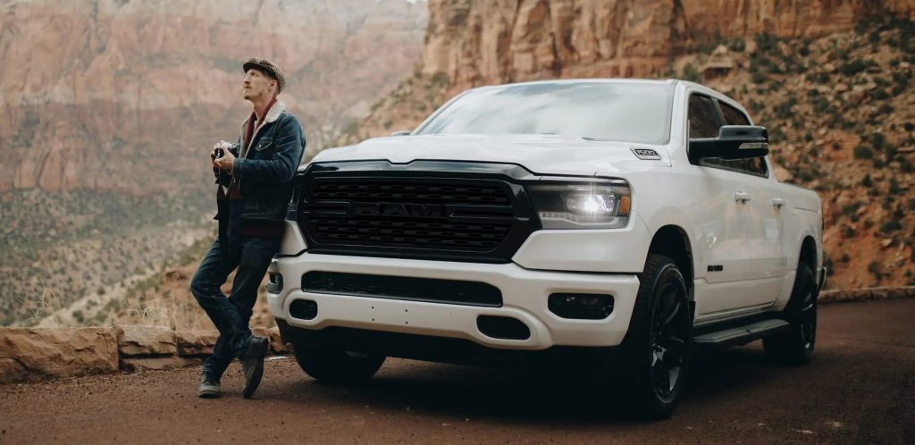 A man leaning against 2022 Ram 1500.