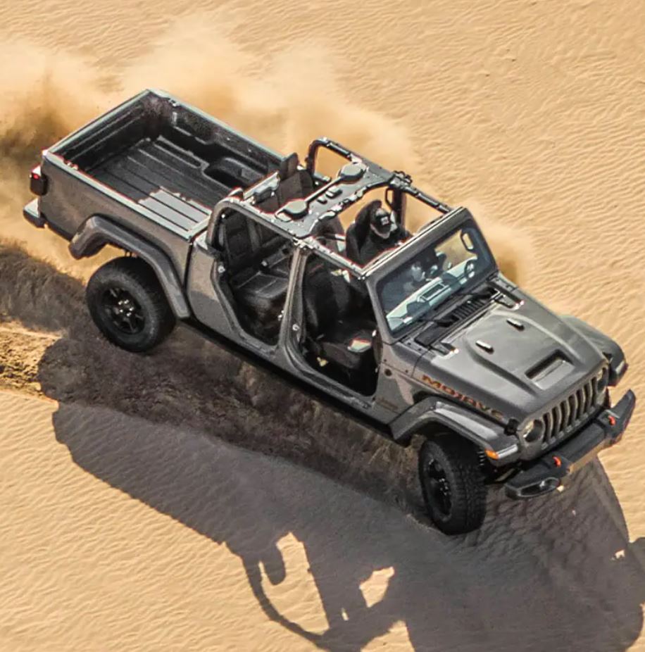 An overhead image of a 2022 Jeep Gladiator driving through the desert with all four doors off.