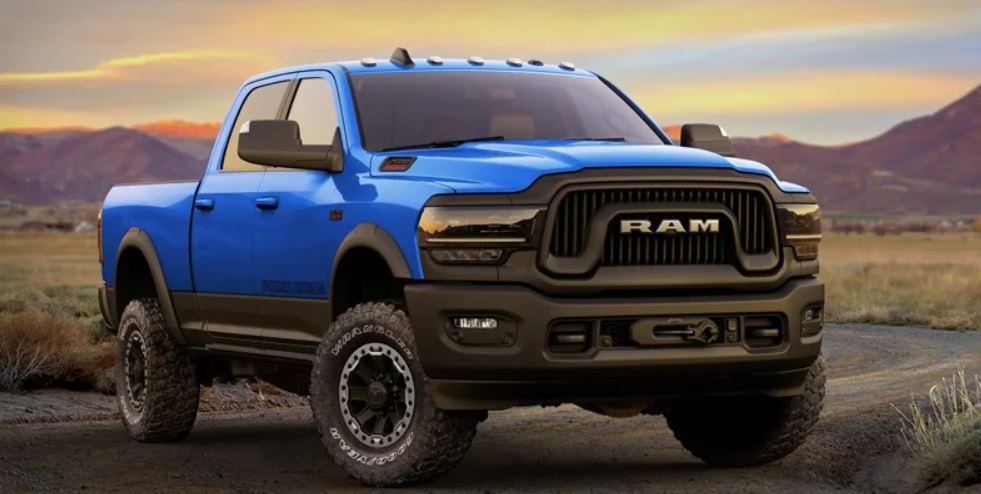A blue 2022 Ram 2500 parked on a desert field in front of a sunset.