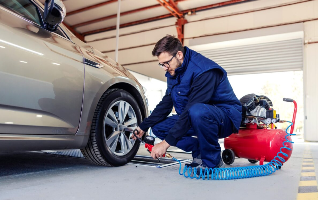 An auto repair service technician fixing tires.